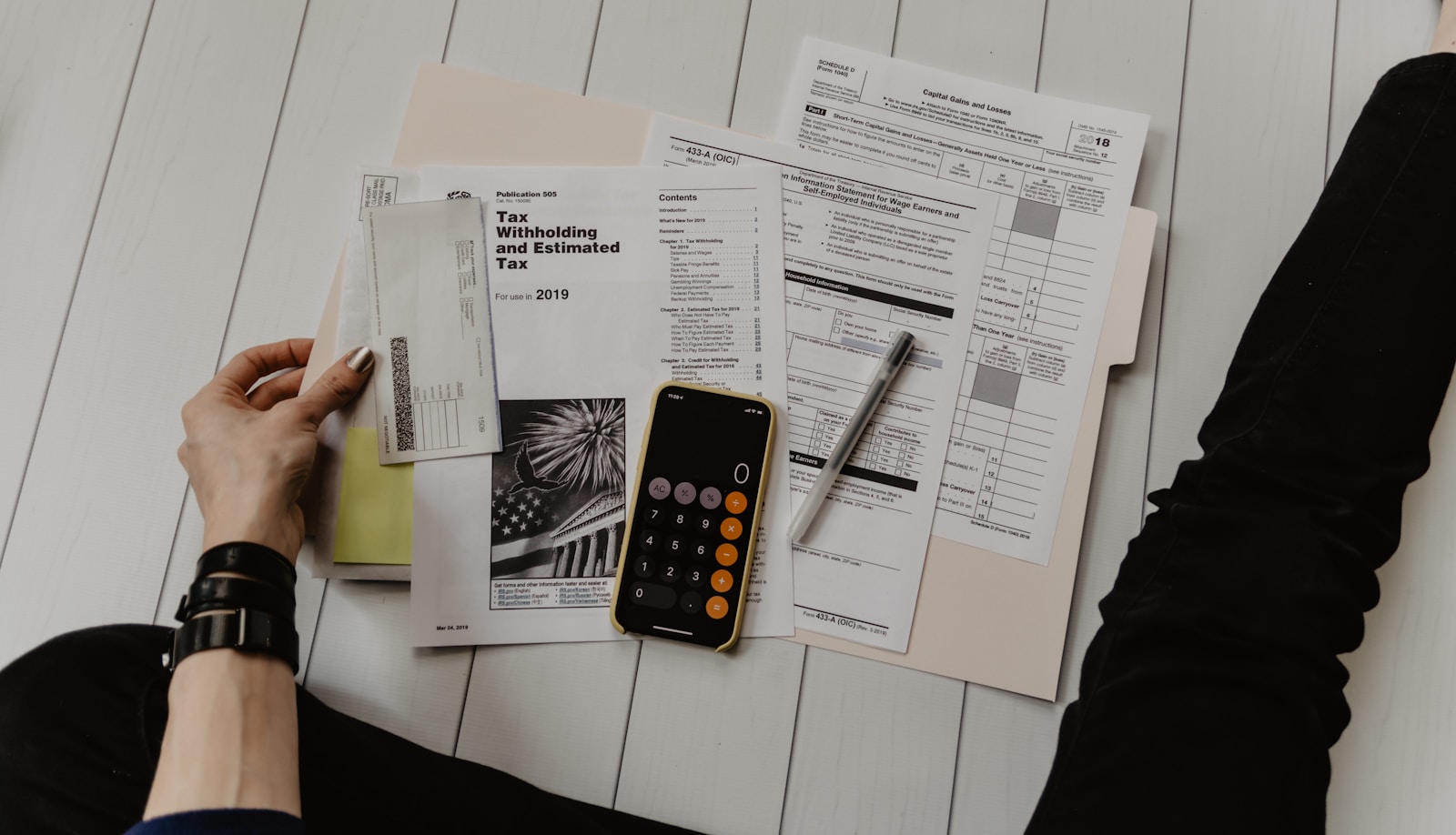 Several tidy stacks of printed documents, spreadsheets, and forms on a desk—evoking separate copies kept for different applications.